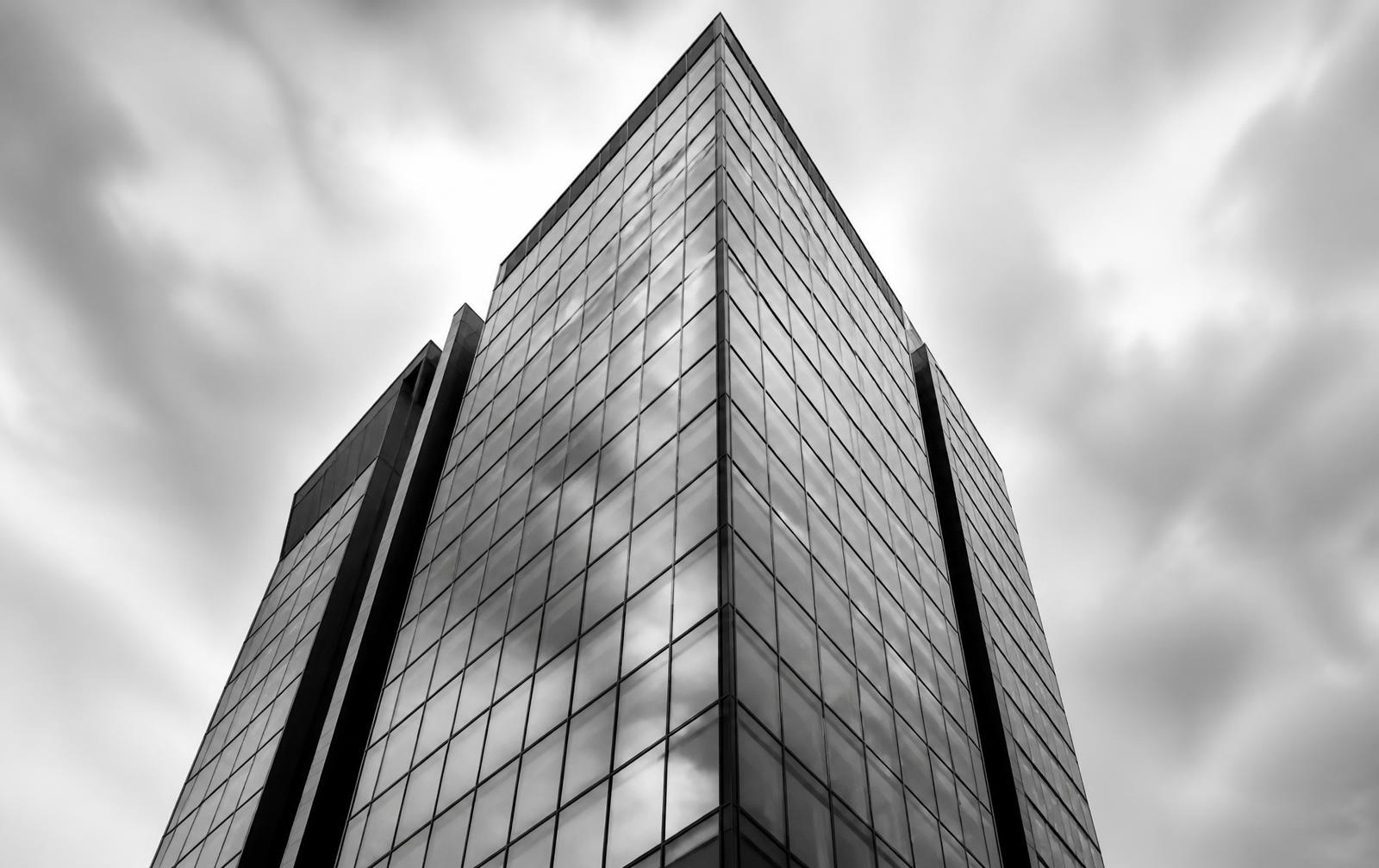 Modern corporate glass tower seen from street level
